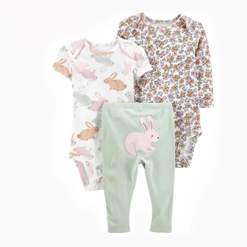Baby clothing set with floral long-sleeve shirt, bunny-themed onesie, and green pants on a white background