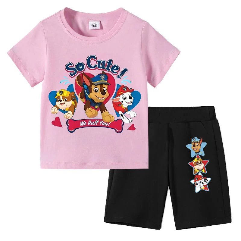 Pink t-shirt with Paw Patrol graphics and black shorts on a white background