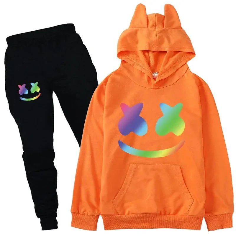 Orange hoodie with colorful smiley face design and black pants with smiley face design on a white background