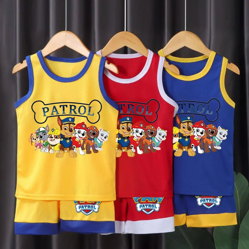 Three children's tank tops with Paw Patrol design on hangers against a dark curtain background.